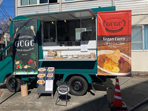 キッチンカーの前に置かれた野菜シルエットのかわい看板