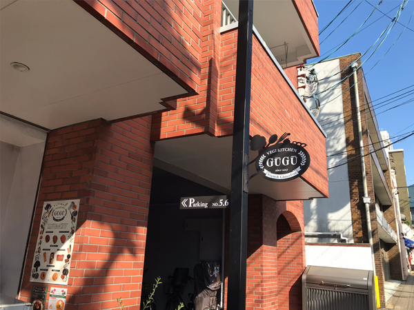 レンガ色の外壁に相性の良い黒い店舗看板と駐車場サイン