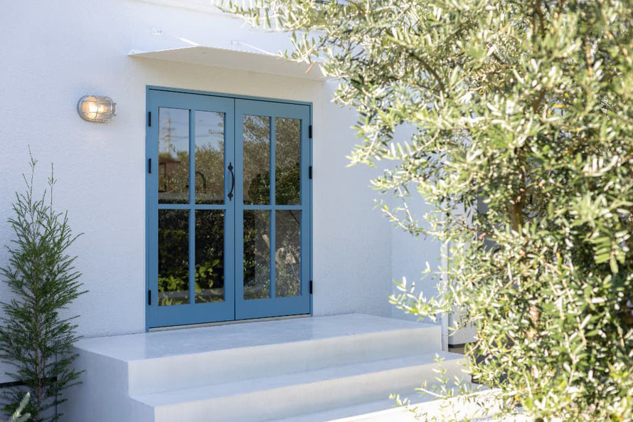 画像 白い壁にブルーの格子扉が海外の様な雰囲気の店舗入り口の様子