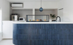 青いおしゃれなタイルのカウンターの上にシンプルなショーケースが載っていて中に美味しそうなシフォンケーキが並んでいる様子