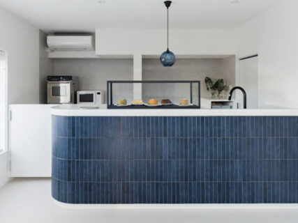 青いおしゃれなタイルのカウンターの上にシンプルなショーケースが載っていて中に美味しそうなシフォンケーキが並んでいる様子