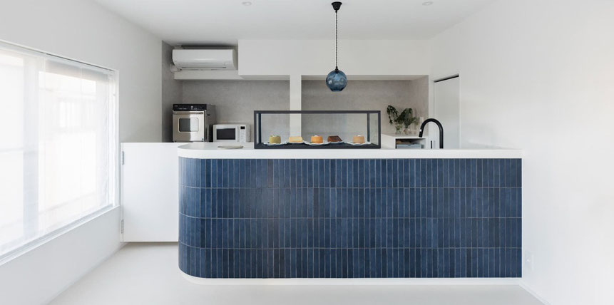 画像 白い空間に青いカウンターとシンプルなガラスケースが置かれ青い吹きガラスの照明が吊るされた店内の様子